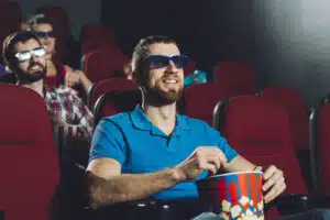 O melhor presente para homem de 50 anos que adoram cinema cheerful-man-watching-film-with-popcorn
