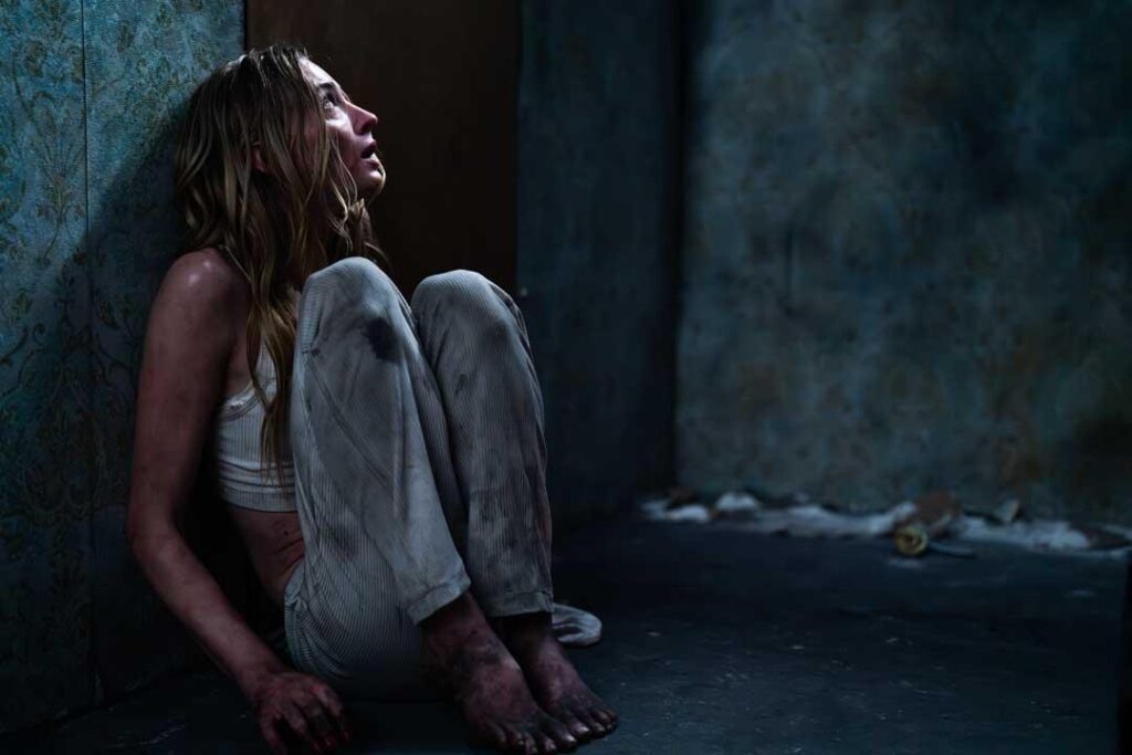 Sophie Turner no filme Confiança da Netflix em cena de tensão na cabana