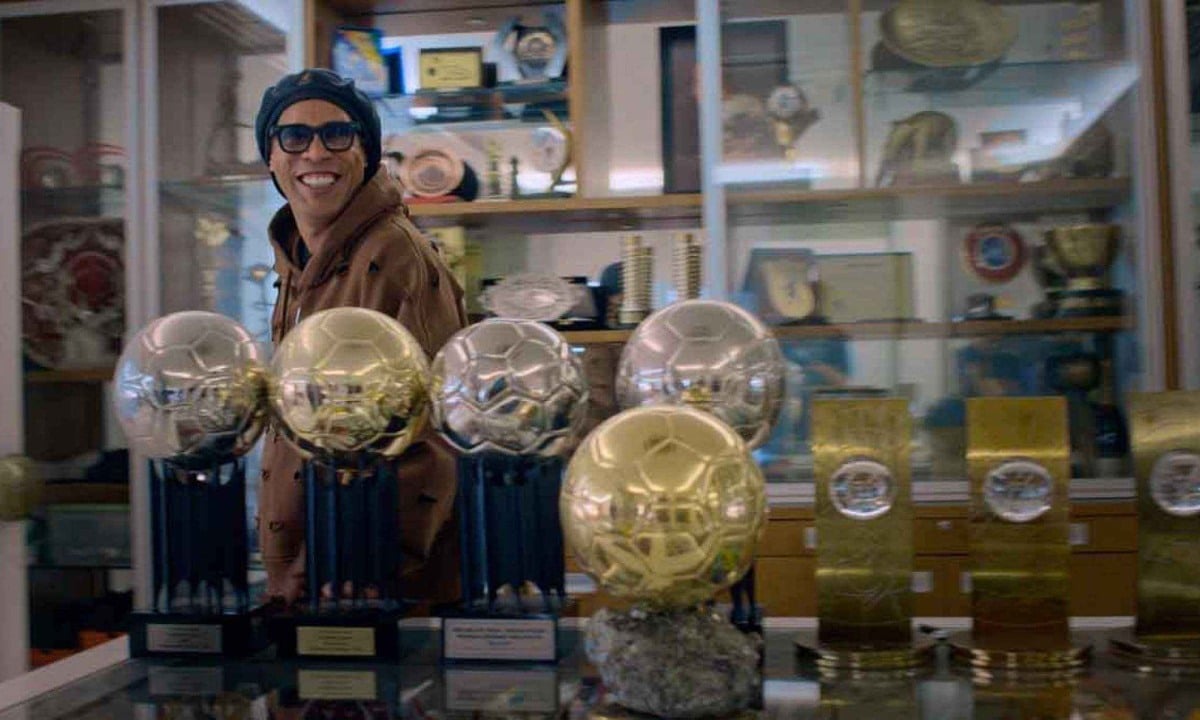 Ronaldinho Gaúcho na sala de troféus em casa mostrando conquistas da carreira