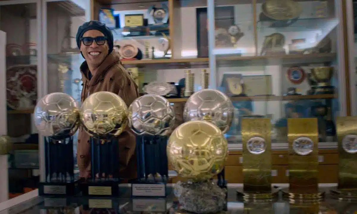 Ronaldinho Gaúcho na sala de troféus em casa mostrando conquistas da carreira