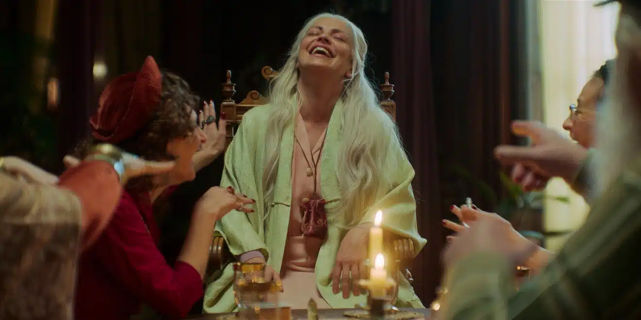 Dolores Fonzi como Clara idosa com cabelos brancos em sessão espírita em cena de A Casa dos Espíritos no Prime Video