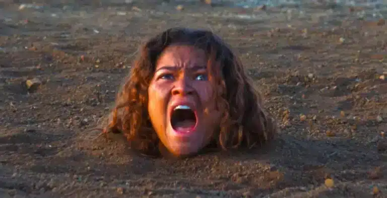 Zendaya como Rue Bennett enterrada até o pescoço no deserto gritando na 3ª temporada de Euphoria na HBO Max