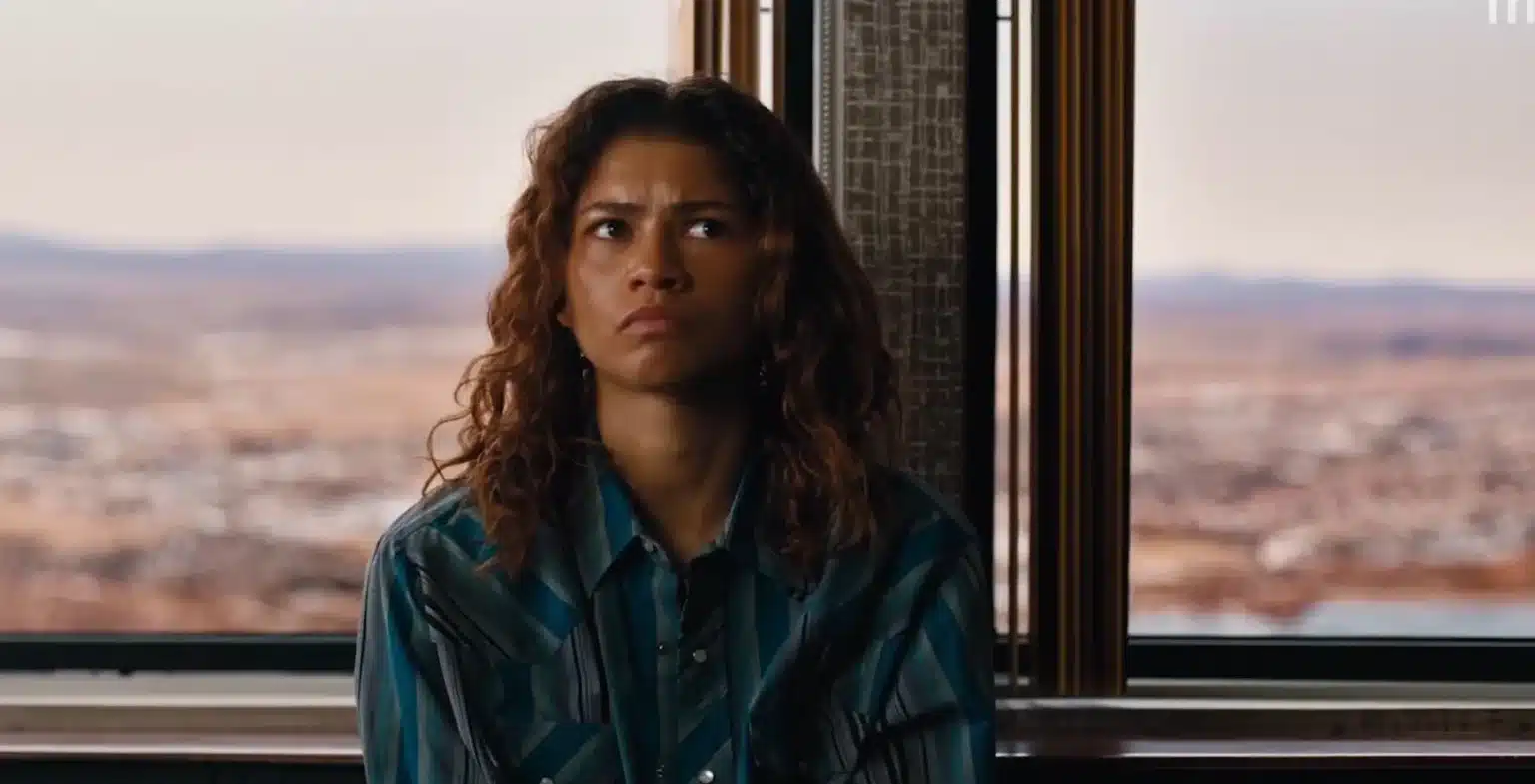 Euphoria T3: Quando Estreia o Episódio 8, o Final “In God We Trust”? Zendaya como Rue Bennett com expressão tensa em frente à janela com paisagem ao fundo na 3ª temporada de Euphoria na HBO Max