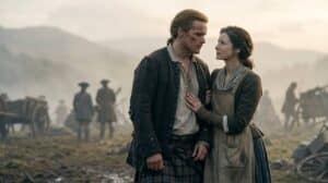 Sam Heughan como Jamie Fraser e Caitriona Balfe como Claire Fraser se olhando no campo de batalha de King's Mountain no final da 8ª temporada de Outlander