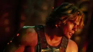 He-Man em pose heroica com espada, cena do filme Mestres do Universo