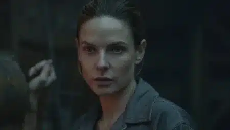 Rebecca Ferguson como Juliette Nichols se ajustando diante do espelho em uniforme de prefeita na 3ª temporada de Silo