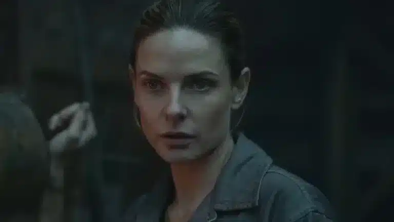 Rebecca Ferguson como Juliette Nichols se ajustando diante do espelho em uniforme de prefeita na 3ª temporada de Silo