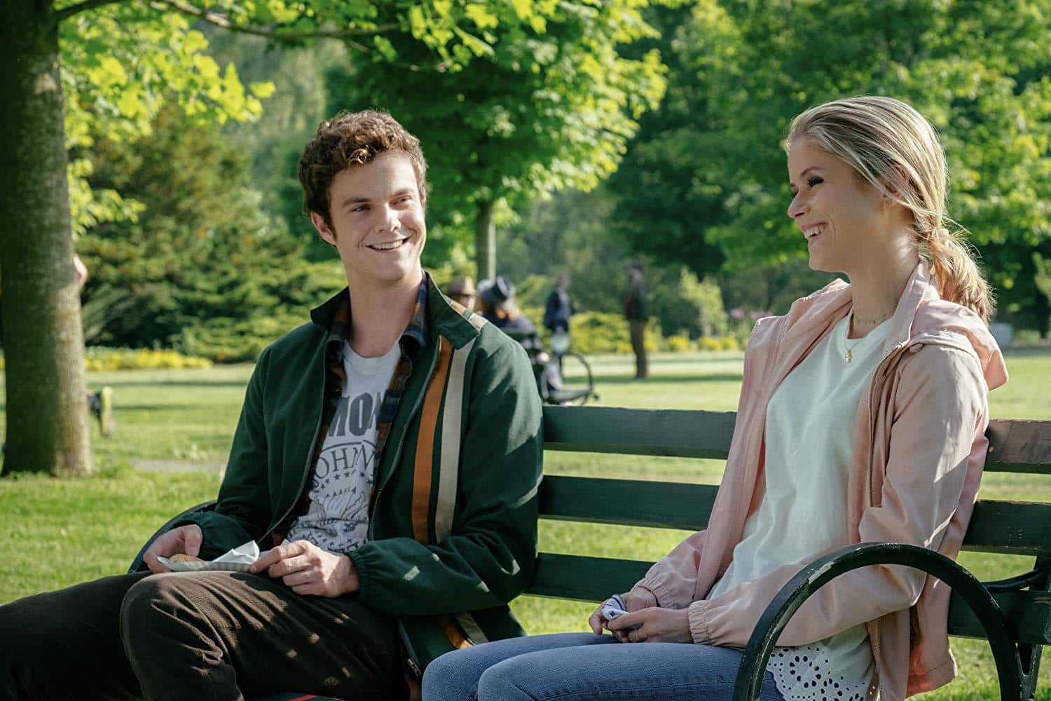 Jack Quaid como Hughie Campbell e Erin Moriarty como Annie January sentados em banco de parque em cena de The Boys no Prime Video
