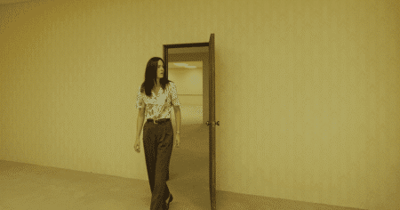Backrooms: um Não-Lugar, por que o filme da A24 não confia na sua maior força Corredor amarelado dos Backrooms com iluminação fluorescente e personagens perdidos no filme de terror da A24