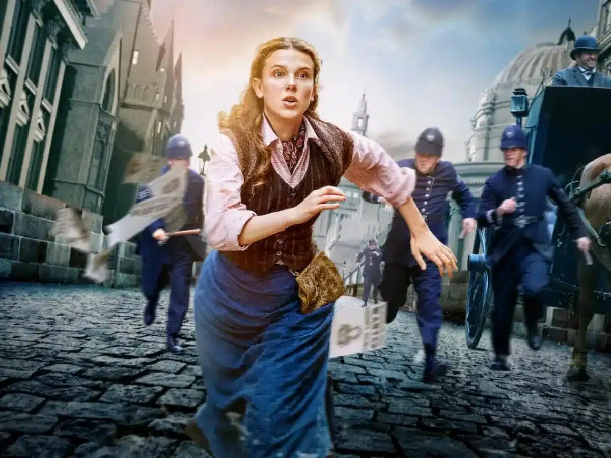 Millie Bobby Brown como Enola Holmes segurando espingarda em cena do filme Enola Holmes 3