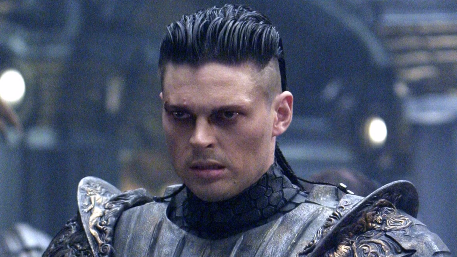 Karl Urban toparia voltar à franquia Riddick com uma condição Cena de As Crônicas de Riddick com personagem em armadura em ambiente sombrio