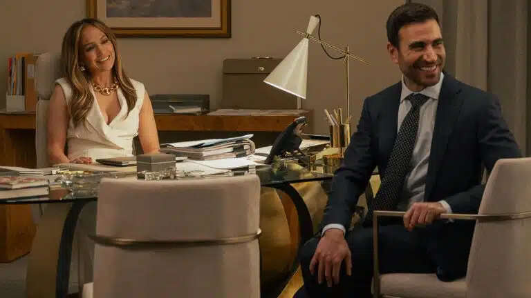 Jennifer Lopez como Jackie Cruz, CEO da Air Cruz em Paixão de Escritório, usando traje executivo em cenário de escritório corporativo