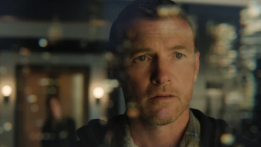 Sam Worthington como David Burroughs em Eu Vou Te Encontrar, expressão de vulnerabilidade emocional