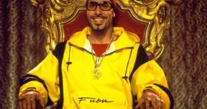 Ali G caracterizado com roupa típica e corrente dourada