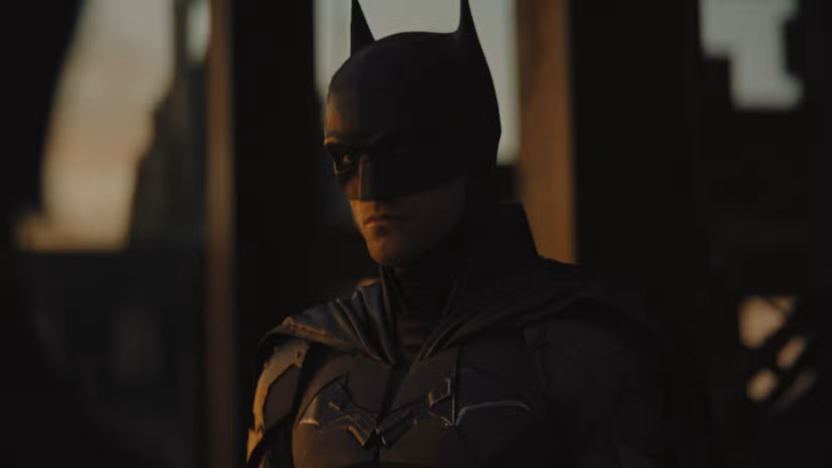Robert Pattinson de traje como Batman com neve ao fundo