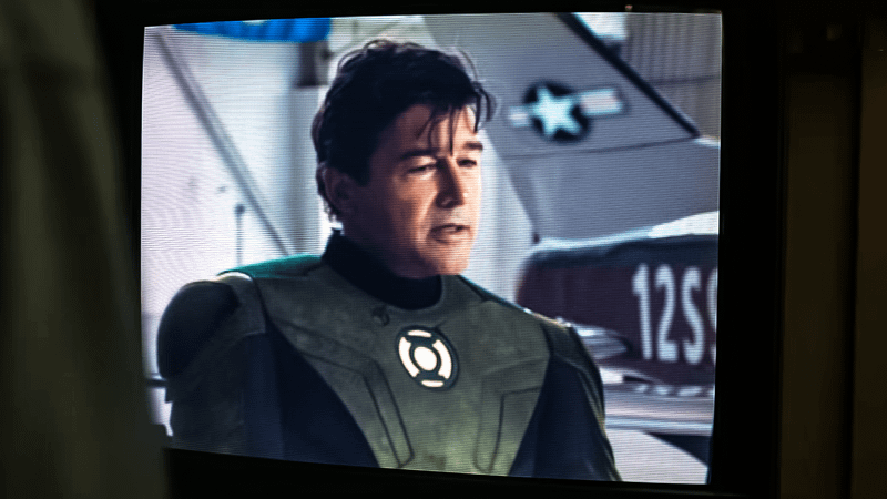 Kyle Chandler como jovem Hal Jordan em entrevista televisiva no flashback de 1996