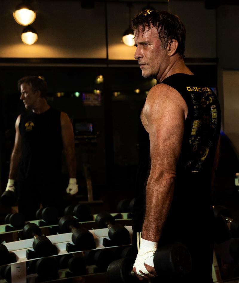 Thomas Jane durante preparação física com faixas brancas