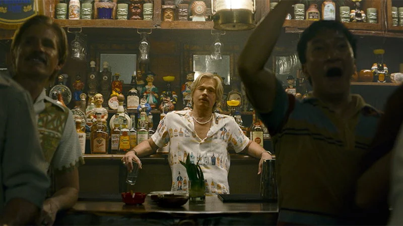 Brad Pitt em cena de bar como Cliff Booth, solucionador de problemas em 1977
